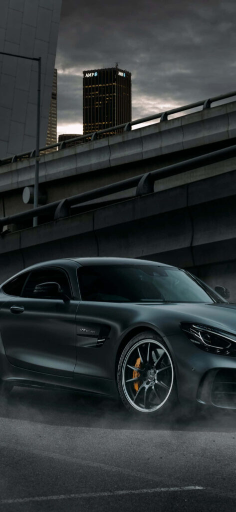 Sleek black Mercedes AMG GT parked under urban overpass with sharp lines city backdrop wallpaper