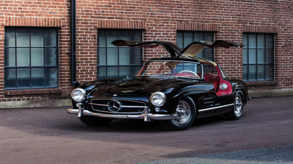 Sleek black Mercedes gullwing car parked by rustic brick building high resolution 4k wallpaper