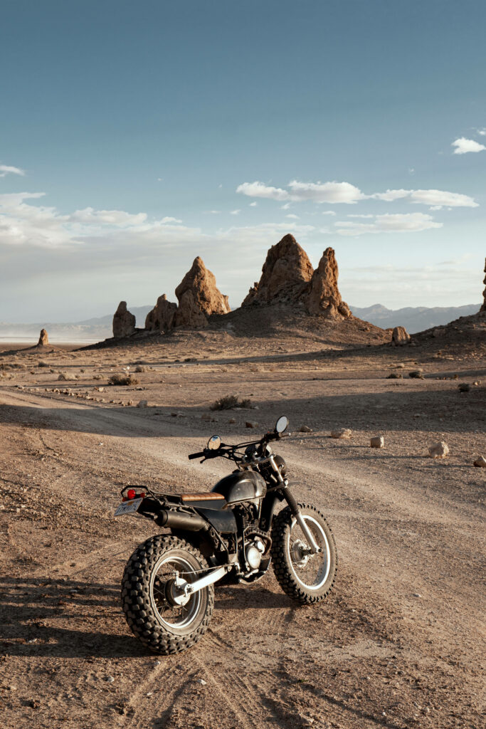 Adventure Awaits: Stunning Black Motorcycle Wallpaper on Rugged Terrain