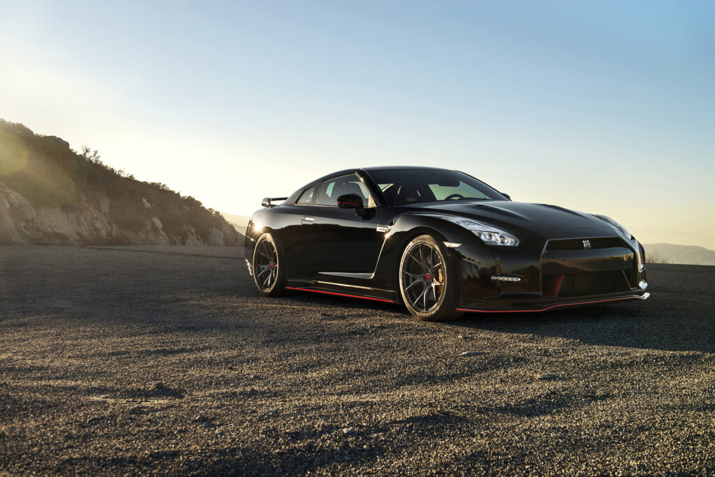 Sleek Black Nissan GT-R Side View Wallpaper on Scenic Open Road