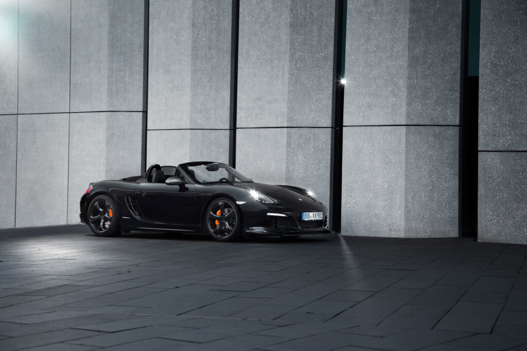 Sleek Black Porsche Boxster Convertible Against Modern Textured Background Wallpaper