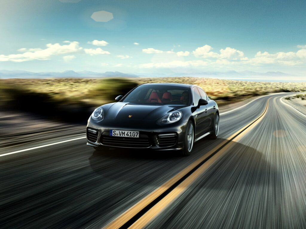 Dynamic Wallpaper: Sleek Black Porsche Panamera on Open Road