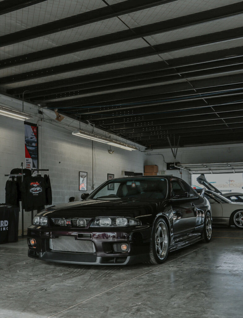 Sleek Black R34 GTR Wallpaper: Industrial Garage Vibe