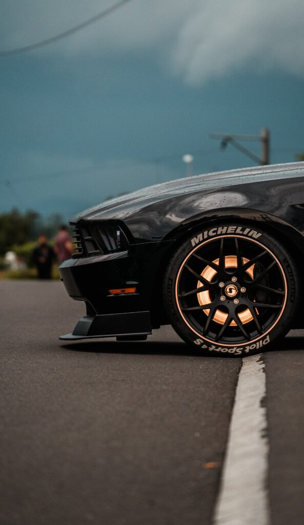 Elegant Black Sports Car Wallpaper: Moody Side View & Detailed Wheel