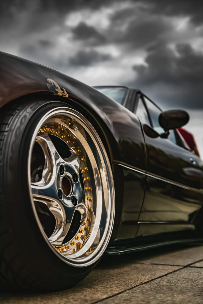Sleek Black Sports Car Wallpaper with Alloy Wheels - Dynamic View