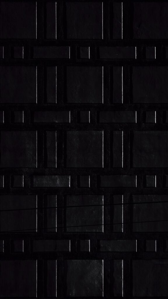 Sleek Black Textured Wallpaper with Geometric Tile Design