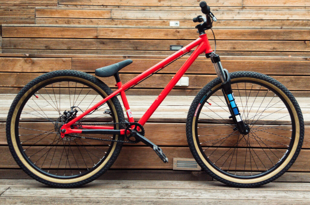 Sleek black and red bike with rugged tires against wooden steps modern cycling wallpaper background