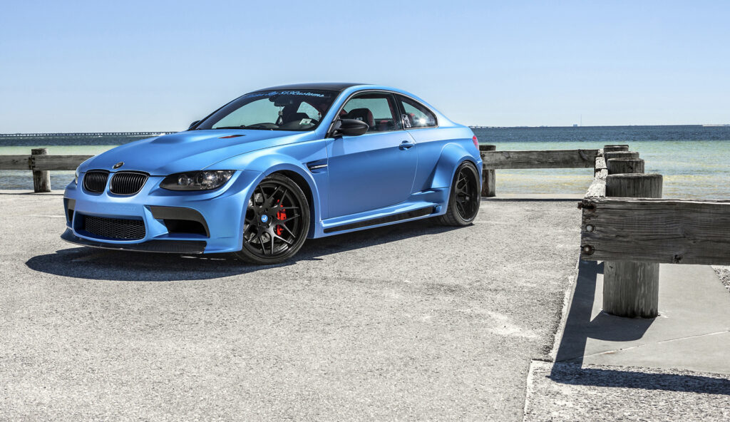 Sleek Blue BMW M3 by Serene Waterfront - Sporty Wallpaper