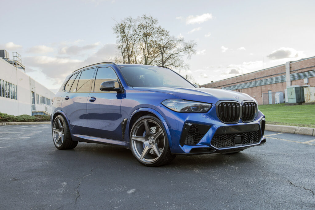 Elegant Blue BMW X5 Wallpaper with Urban Background and Clear Sky