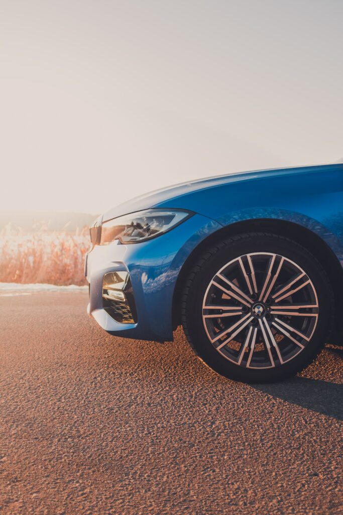 Stylish Blue Car Side View Wallpaper with Dynamic Outdoor Background