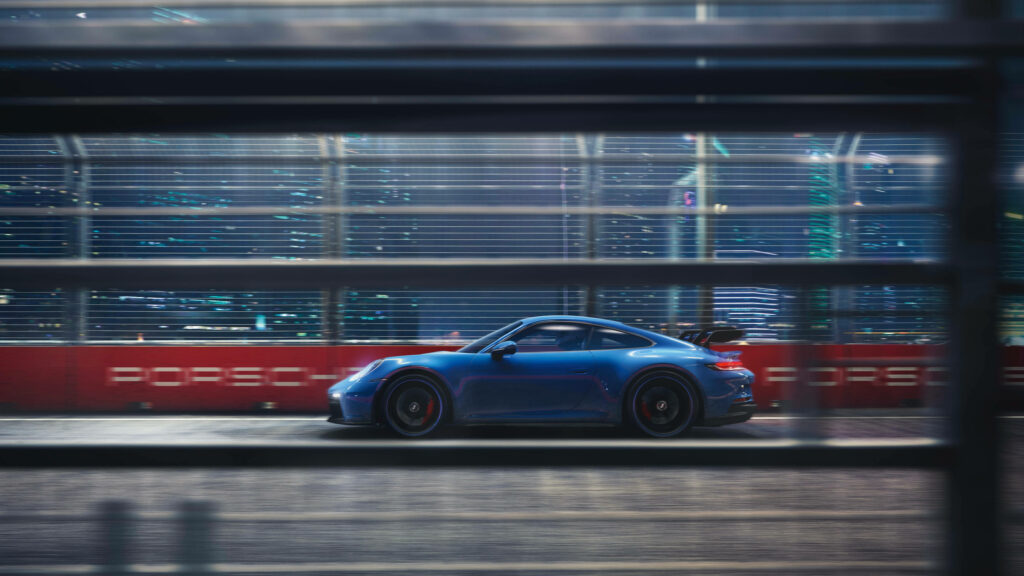 Sleek Blue Porsche 911 in Motion: Dynamic Racetrack Wallpaper
