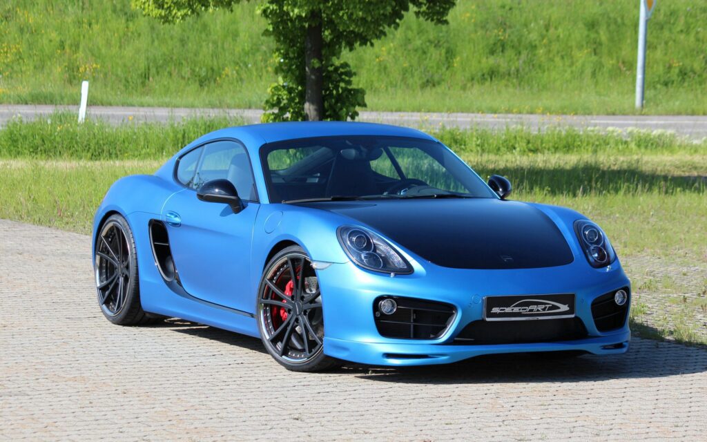 Sleek Blue Porsche Cayman S SpeedART SP81-CR 360 with Lush Green Background Wallpaper