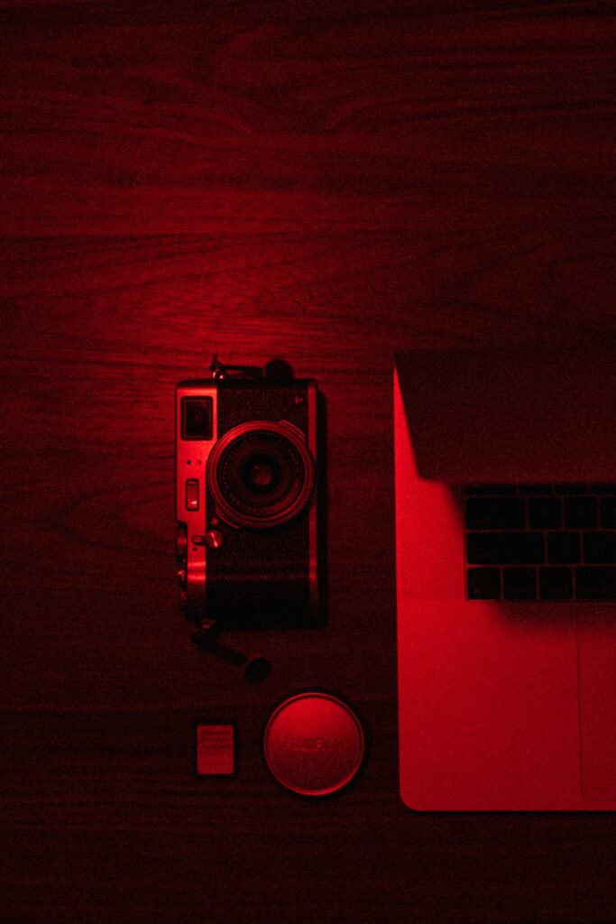Modern Minimalist Wallpaper: Red Glow Camera & Laptop Essentials