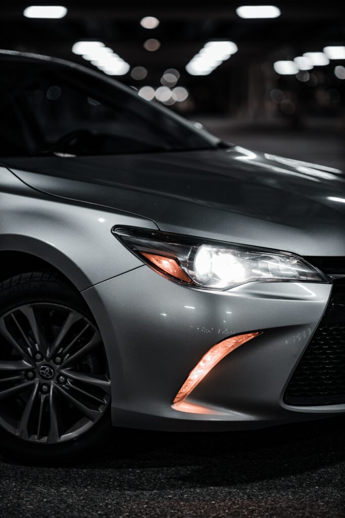 Sleek Car Wallpaper: Headlight & Wheel in Dramatic Blurred Background