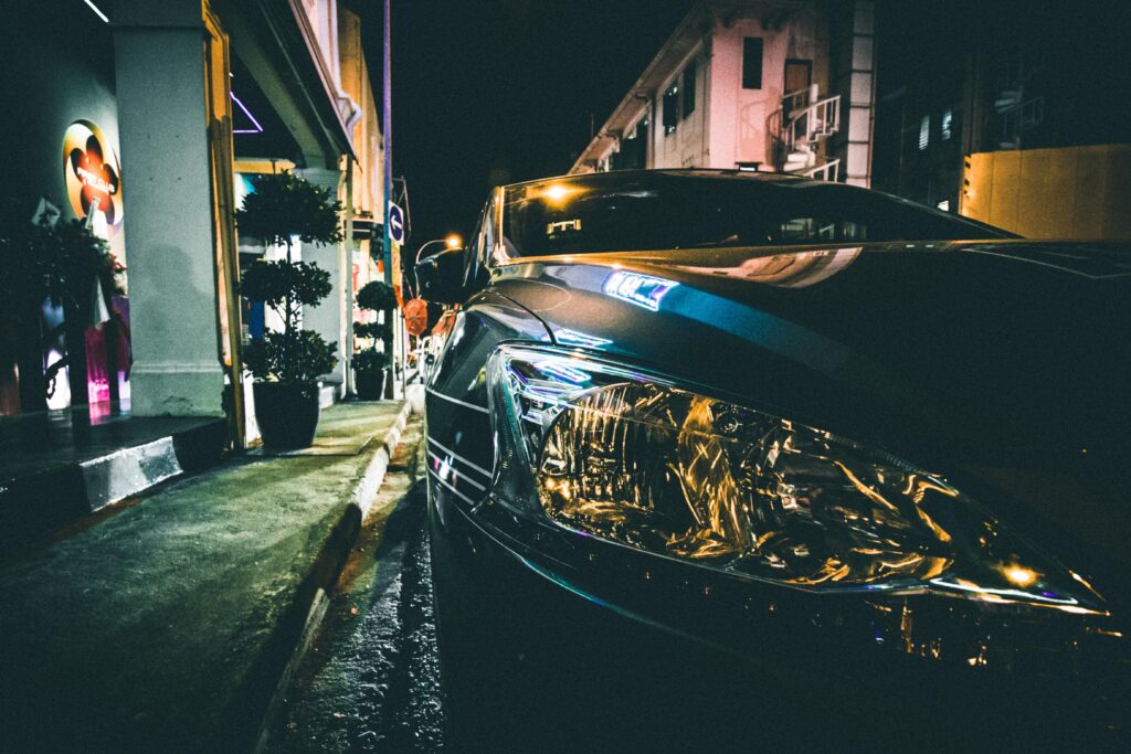 Sleek Car Reflection in Dimly-Lit Evening Street - Urban Ambiance Wallpaper