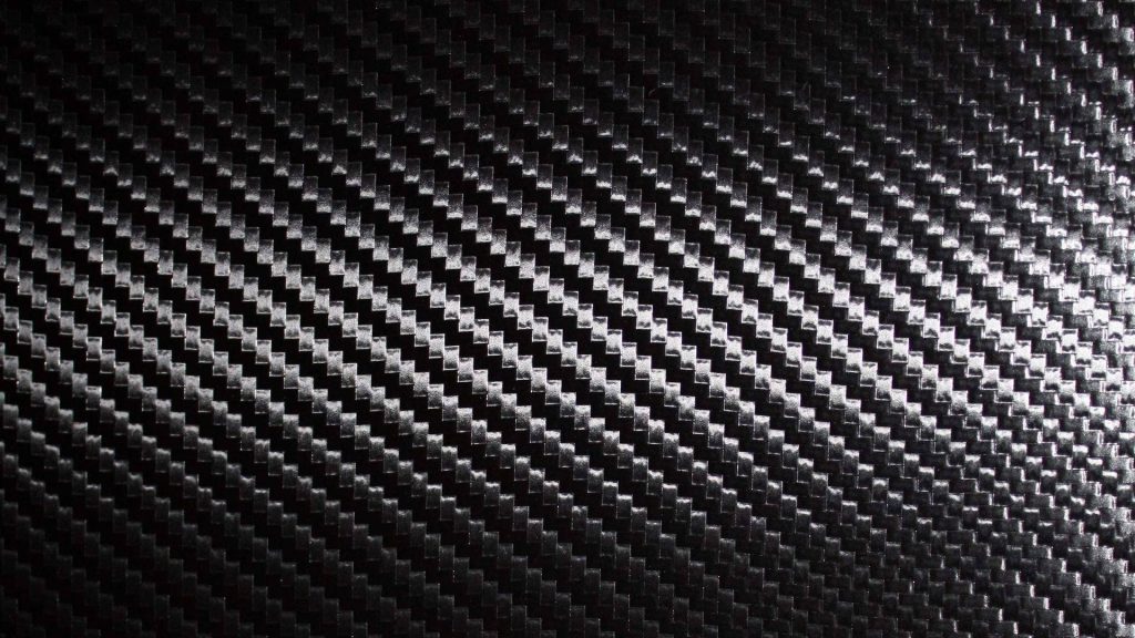 High-resolution carbon fiber wallpaper with dark grey twill weave and glossy reflective sheen