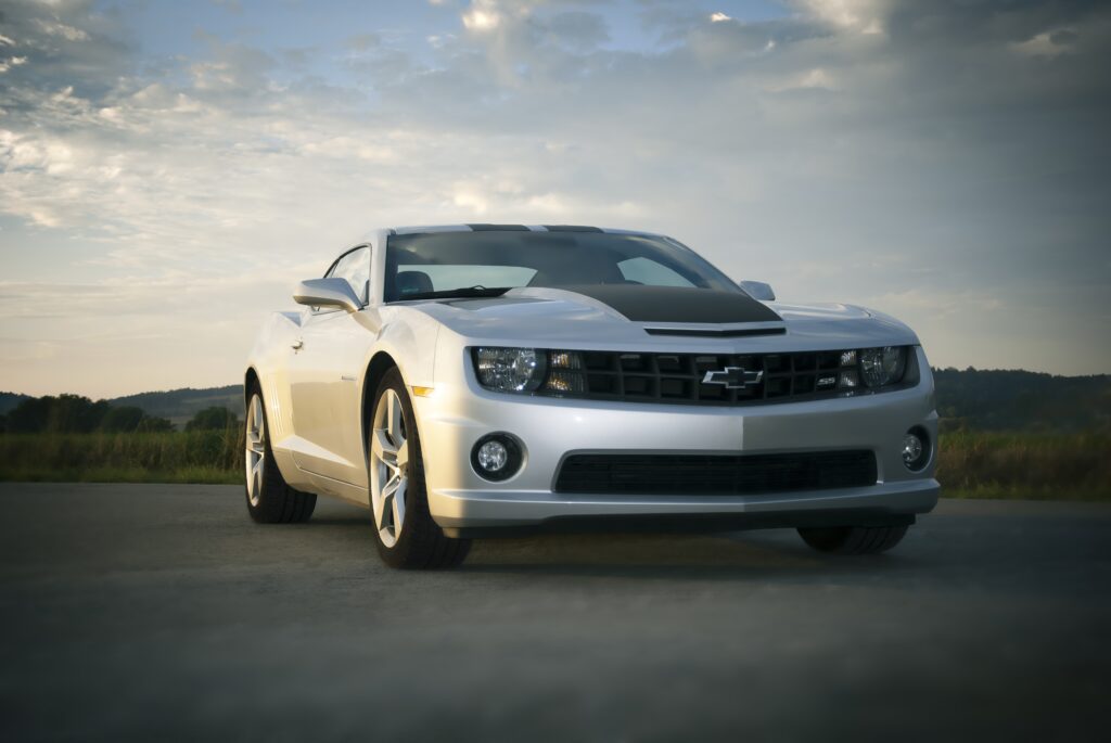 Sleek Chevrolet Camaro on Asphalt with Serene Cloudy Sky Background Wallpaper