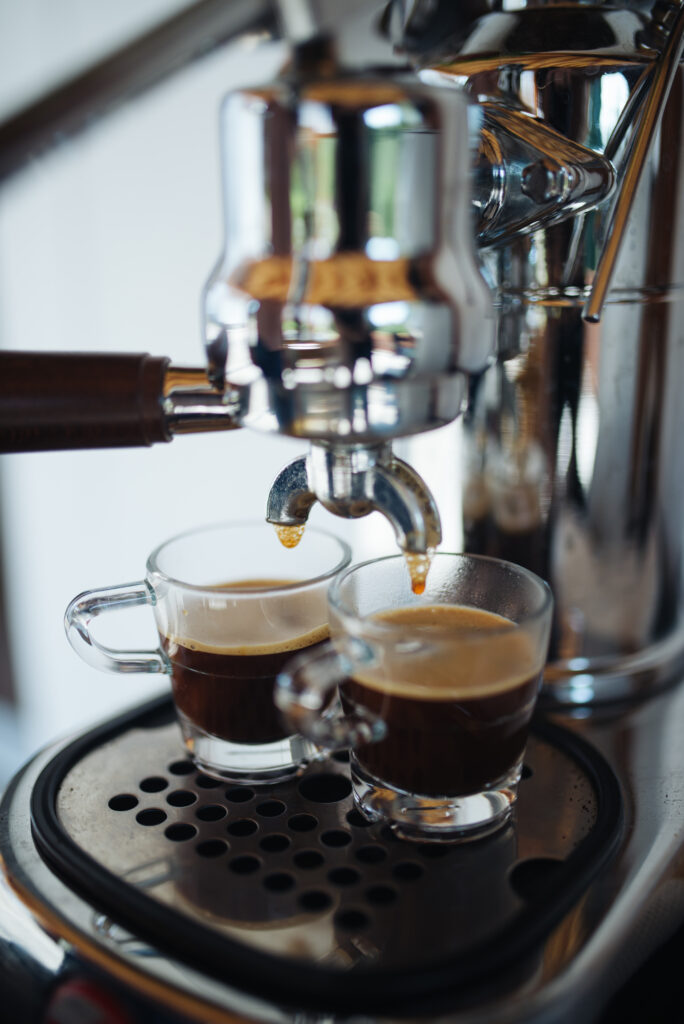 Sleek Coffee Machine Pouring Rich Espresso - Wallpaper Background
