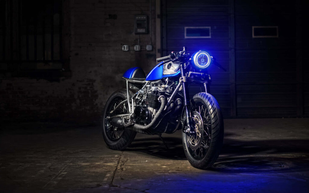 Custom Motorcycle Wallpaper: Vibrant Blue Headlight in Industrial Setting