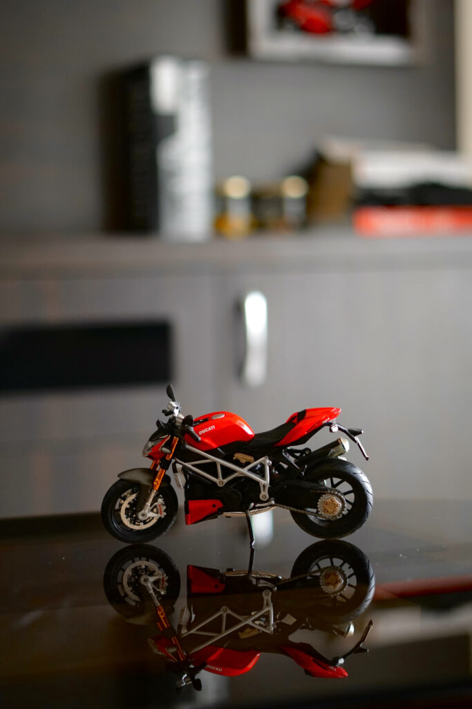 Vibrant Ducati Red Bike Toy Model Wallpaper on Reflective Surface
