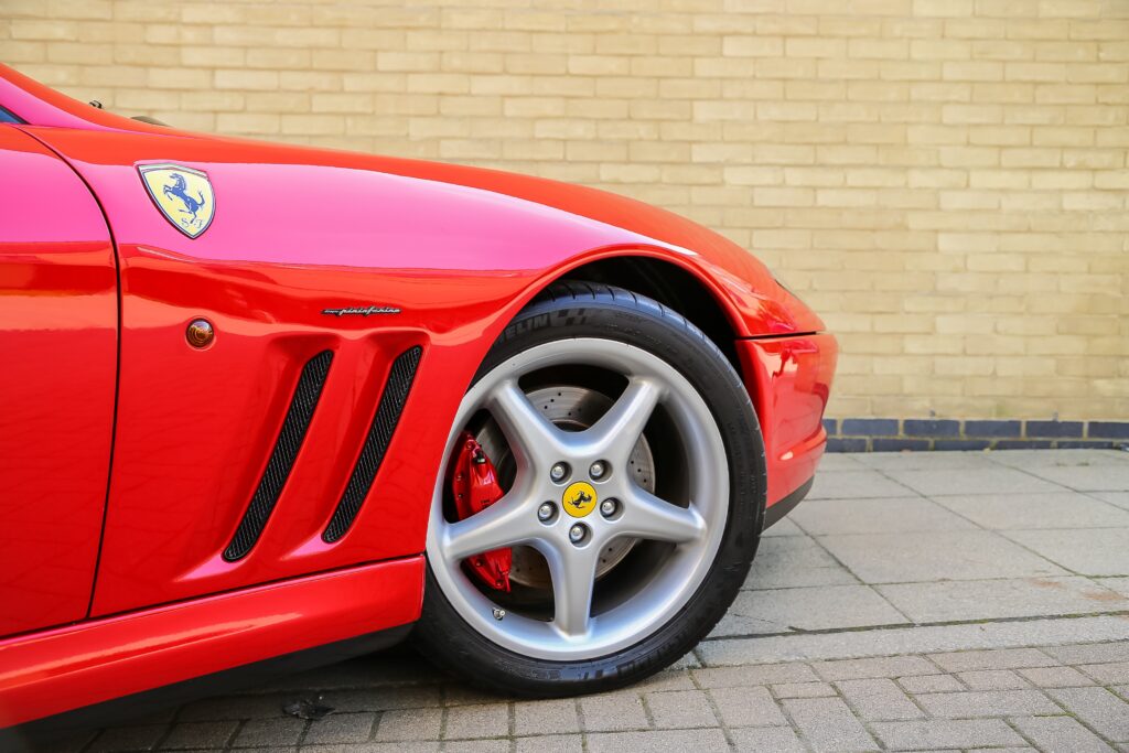 Sleek Ferrari Wallpaper: Polished Red Against Neutral Brick Wall