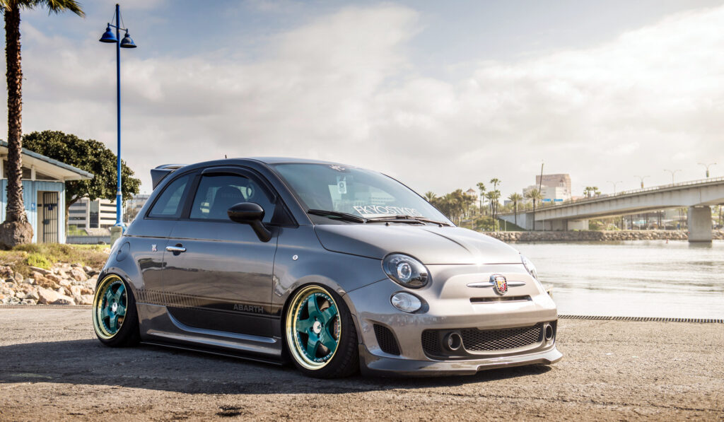 Custom Fiat 500 Abarth Wallpaper with Scenic Waterfront Background