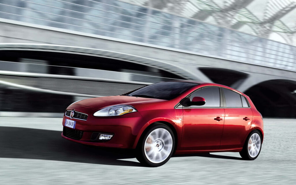 Sleek Fiat Bravo Wallpaper: Modern Design in Vibrant Red Urban Scene