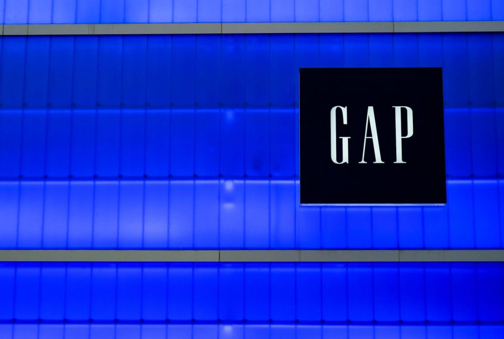 Gap logo wallpaper with white logo on black square and blue ribbed architectural wall background