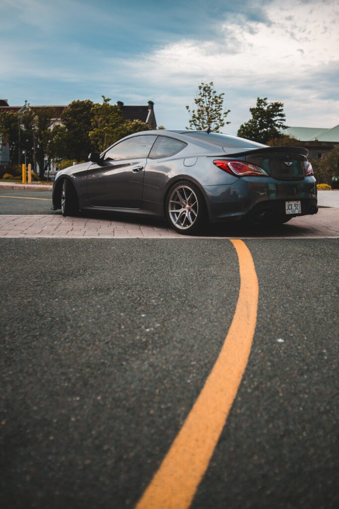 Sleek Genesis Sports Car Wallpaper on Scenic Winding Road
