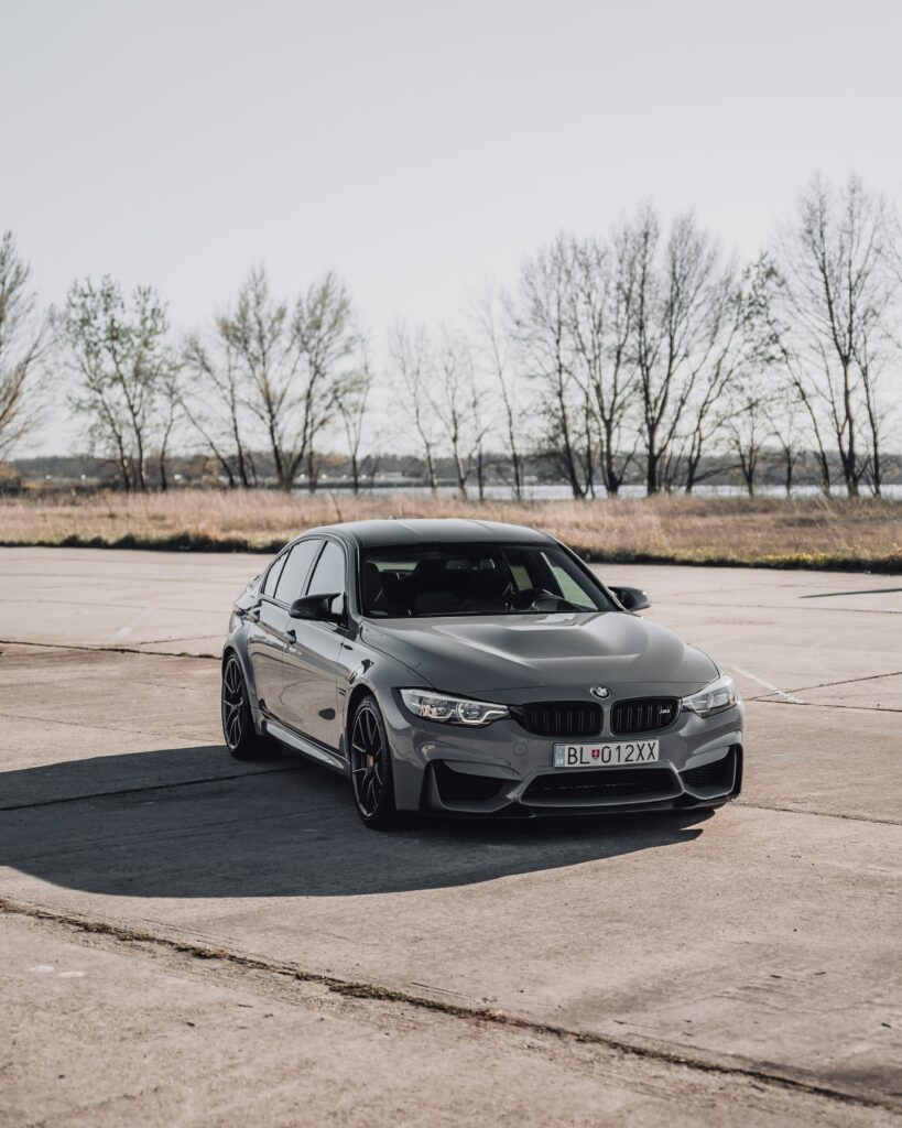 Stylish Gray BMW Wallpaper: Front View in Scenic Outdoor Setting