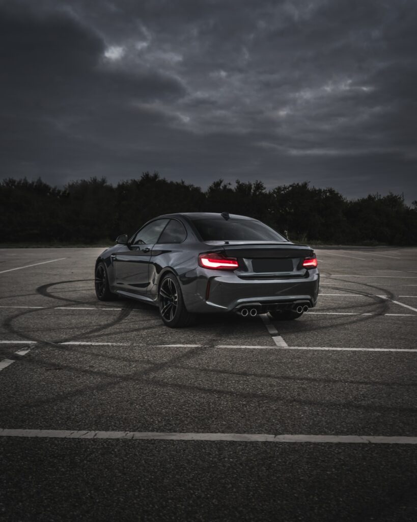 Stunning Gray BMW M3 Rear View on Asphalt with Dramatic Skies Wallpaper