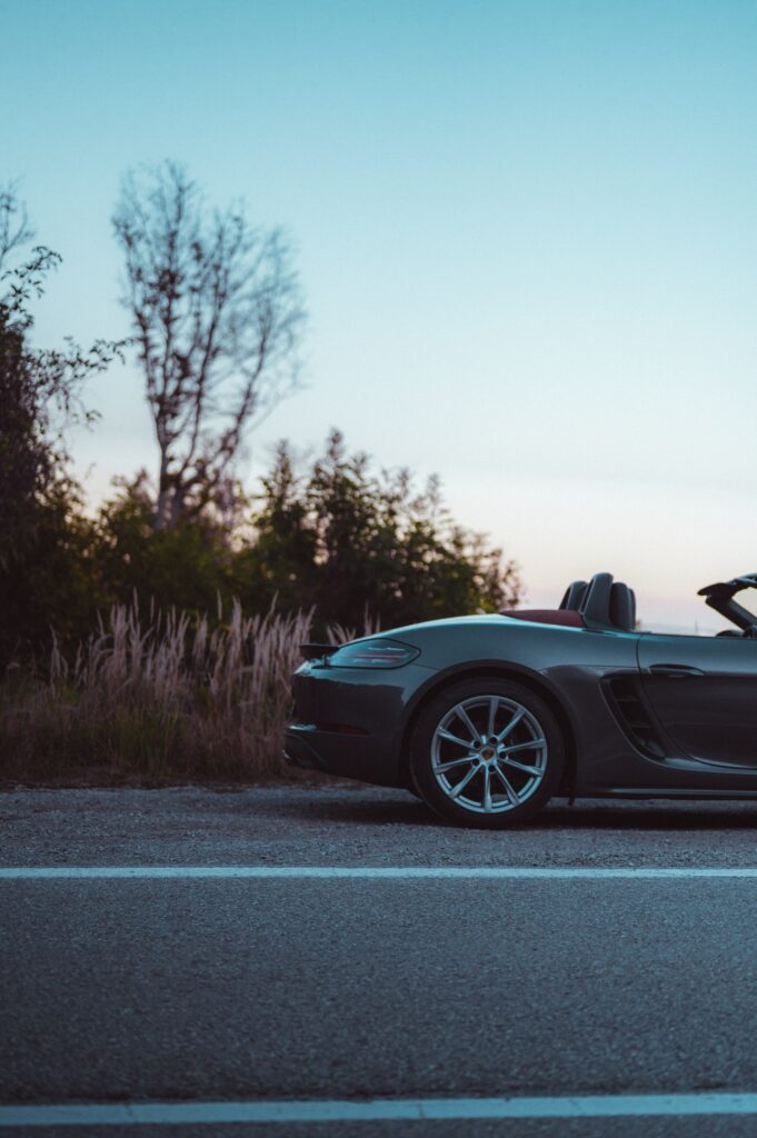 Sleek Gray Convertible Car Among Lush Greenery on Asphalt Road Wallpaper