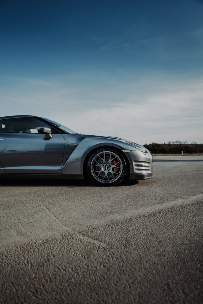 Sleek Gray Nissan GT-R Wallpaper on Open Asphalt with Clear Sky