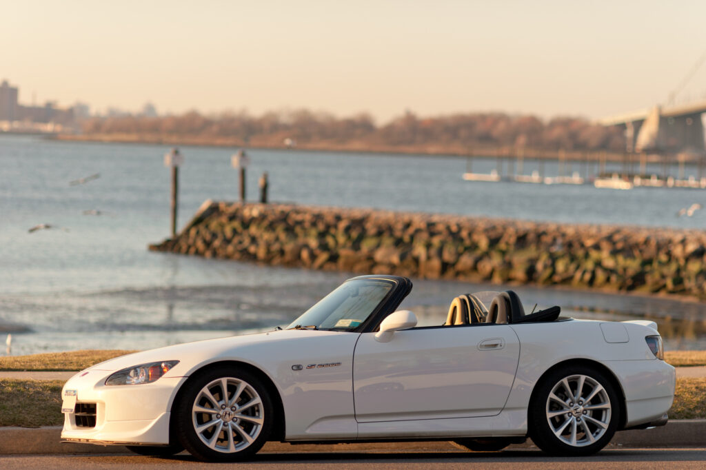Sleek White Honda S2000 Convertible by Serene Waterfront Background Wallpaper