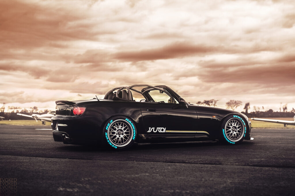 Sleek Honda S2000 Convertible on Asphalt with Custom Rims & Sky Wallpaper