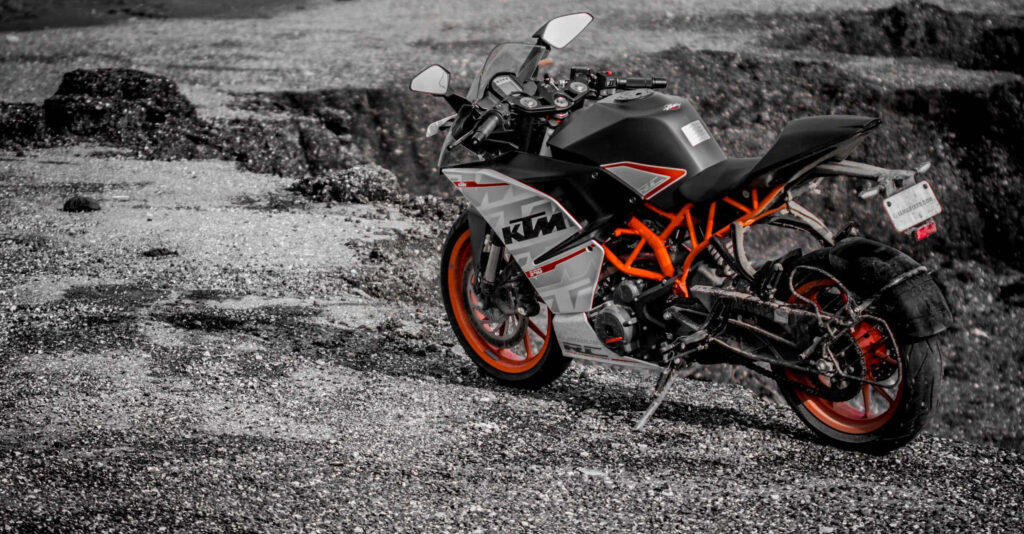 Stunning KTM Motorcycle Wallpaper: Vibrant Orange on Rugged Gravel