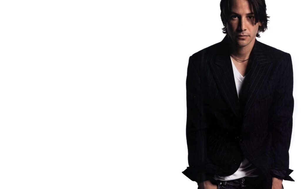 Minimalist Keanu Reeves Wallpaper: Stylish Black Suit on White Background