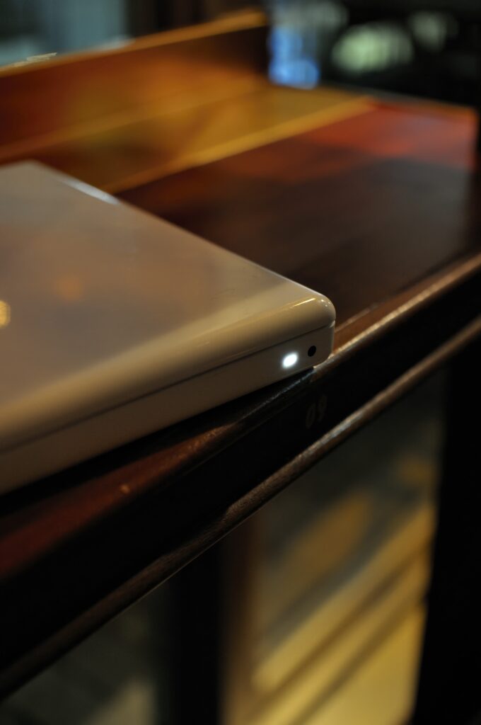 Sleek Laptop on Dark Table: Cozy, Calming Wallpaper Background