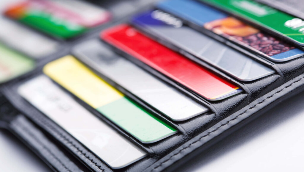 Close-up of sleek leather wallet with colorful electronic credit cards showcasing modern payments Wallpaper