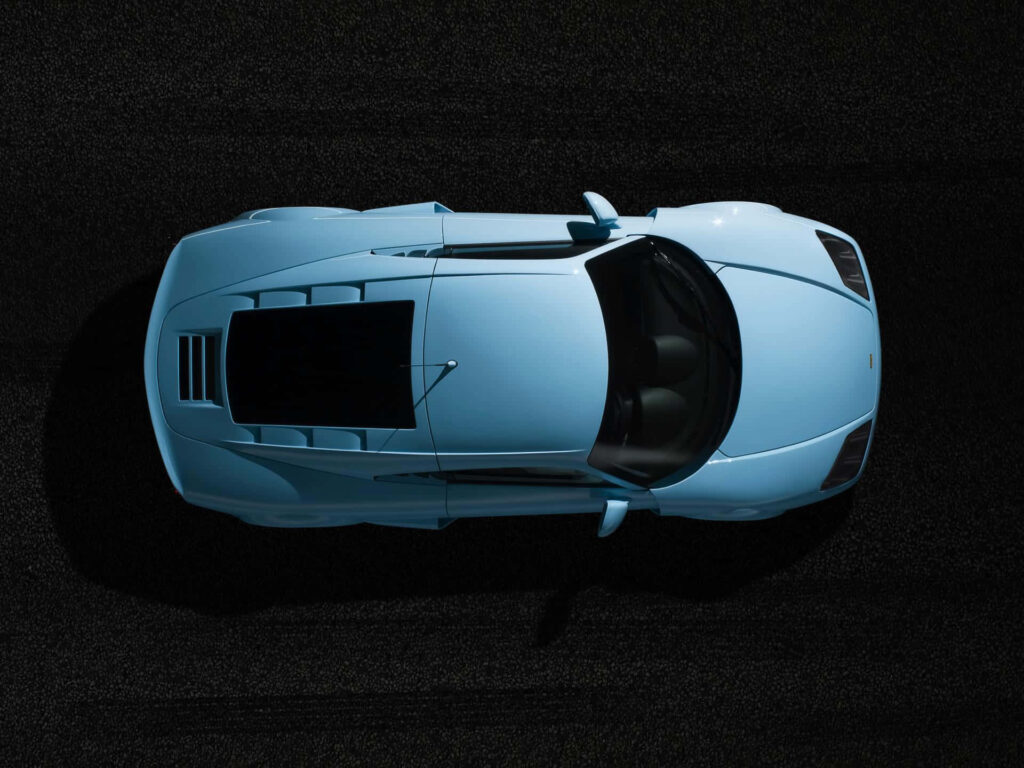 Top view of sleek light blue Noble car showing aerodynamic design and elegant curves on dark background Wallpaper