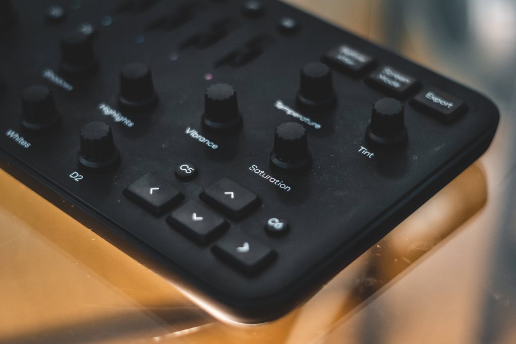Close-up of matte black Loupedeck editing console with tactile dials and labeled color controls Wallpaper