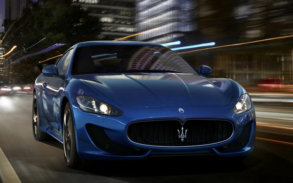 Sleek Maserati Night Drive: Dynamic Urban Wallpaper with City Lights