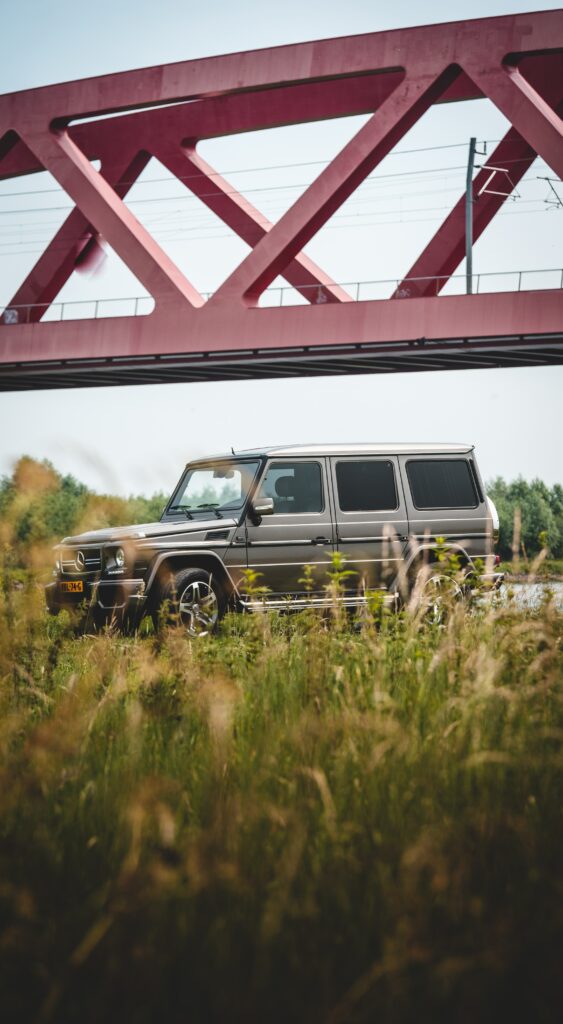 Sleek Mercedes-Benz SUV on Red Bridge with Lush Greenery Wallpaper