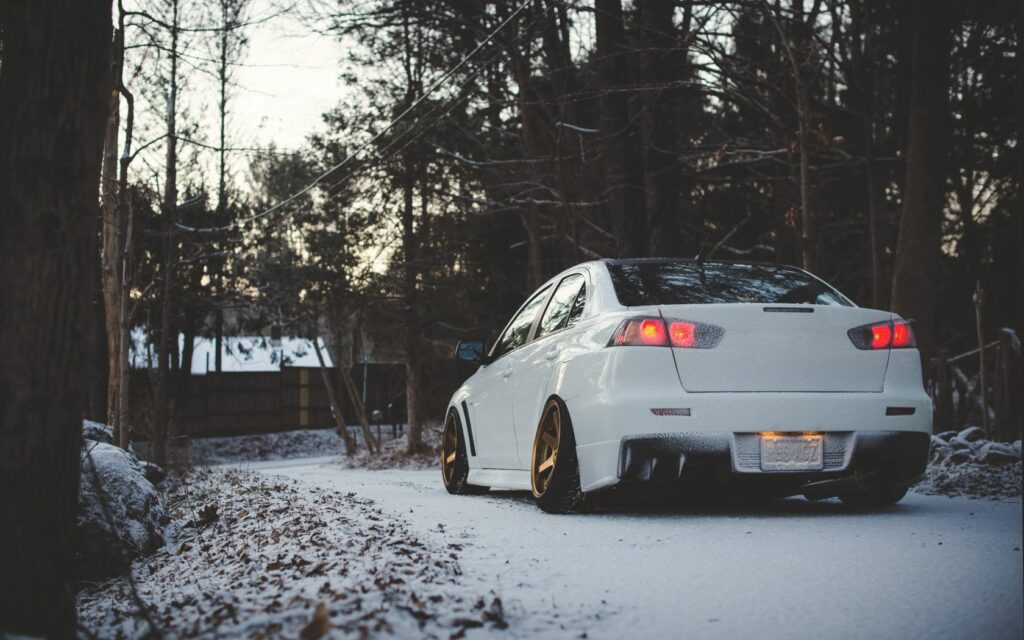 Sleek Mitsubishi Lancer in Winter Forest - Rear View Wallpaper