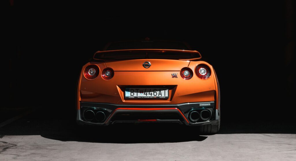 Stunning Rear View of Orange Nissan GT-R Against Dark Background Wallpaper