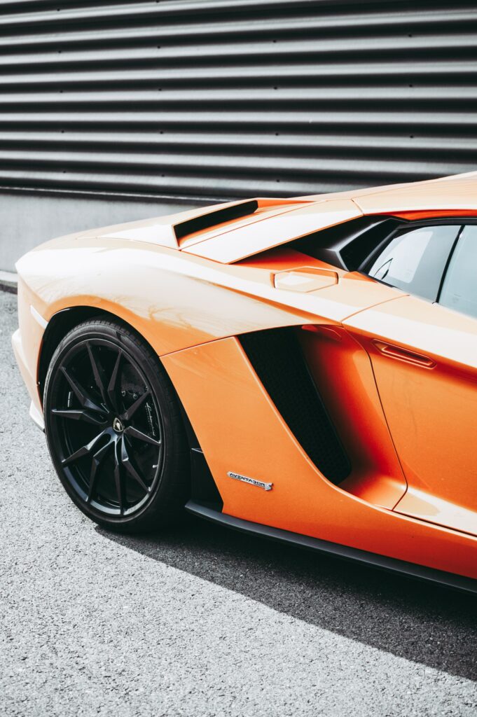 Sleek Orange Sports Car Wallpaper: Aerodynamic Design & Modern Backdrop