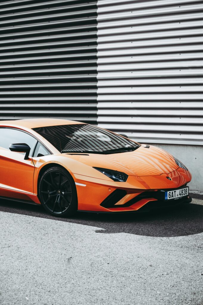 Sleek Orange Sports Car Wallpaper: Urban Style & Luxury Design