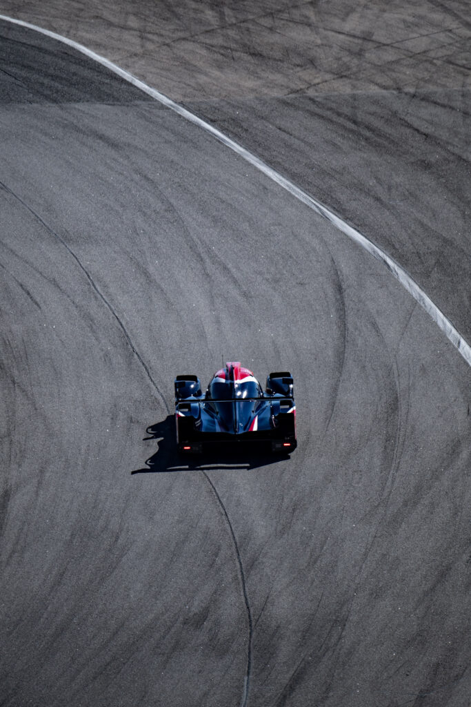 Sleek Racing Car Wallpaper: Dynamic Motion on Winding Road