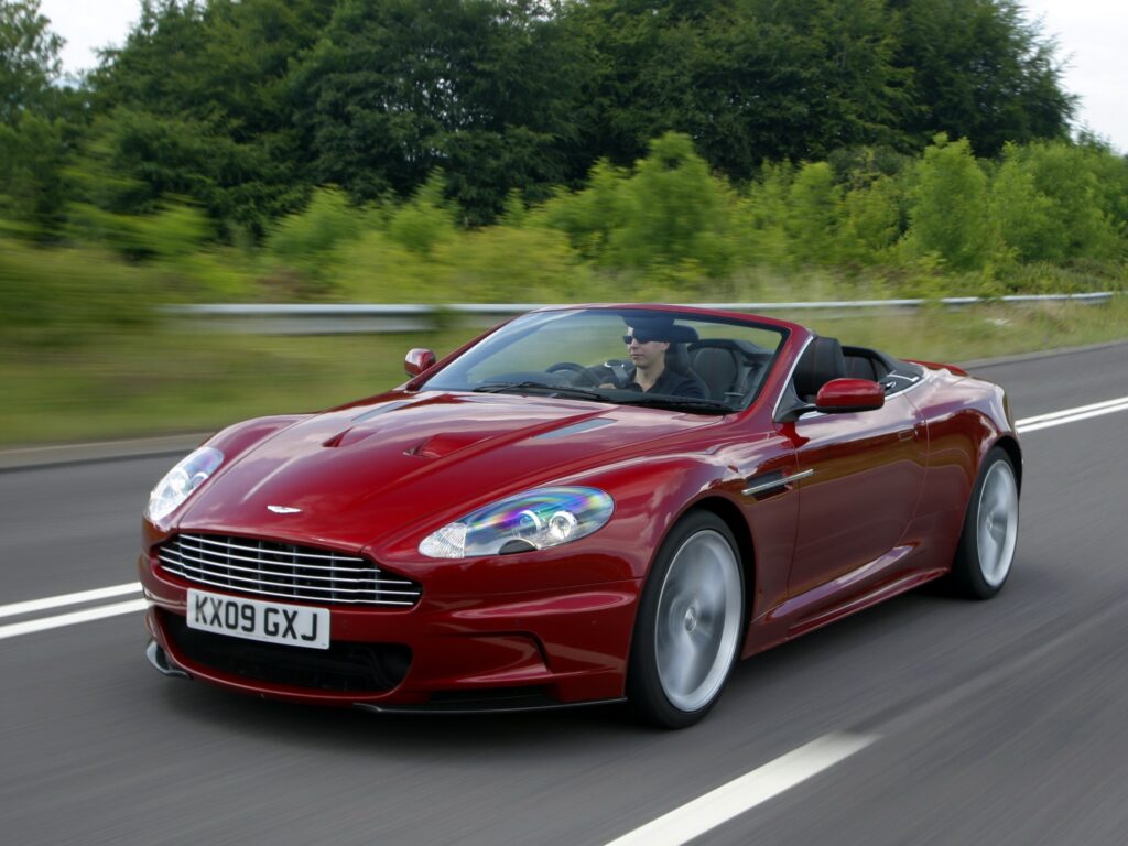 Elegant Red 2009 Aston Martin DBS on Scenic Road - Wallpaper