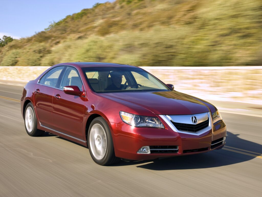 Sleek Red Acura RL: Dynamic Front View Wallpaper in Scenic Setting